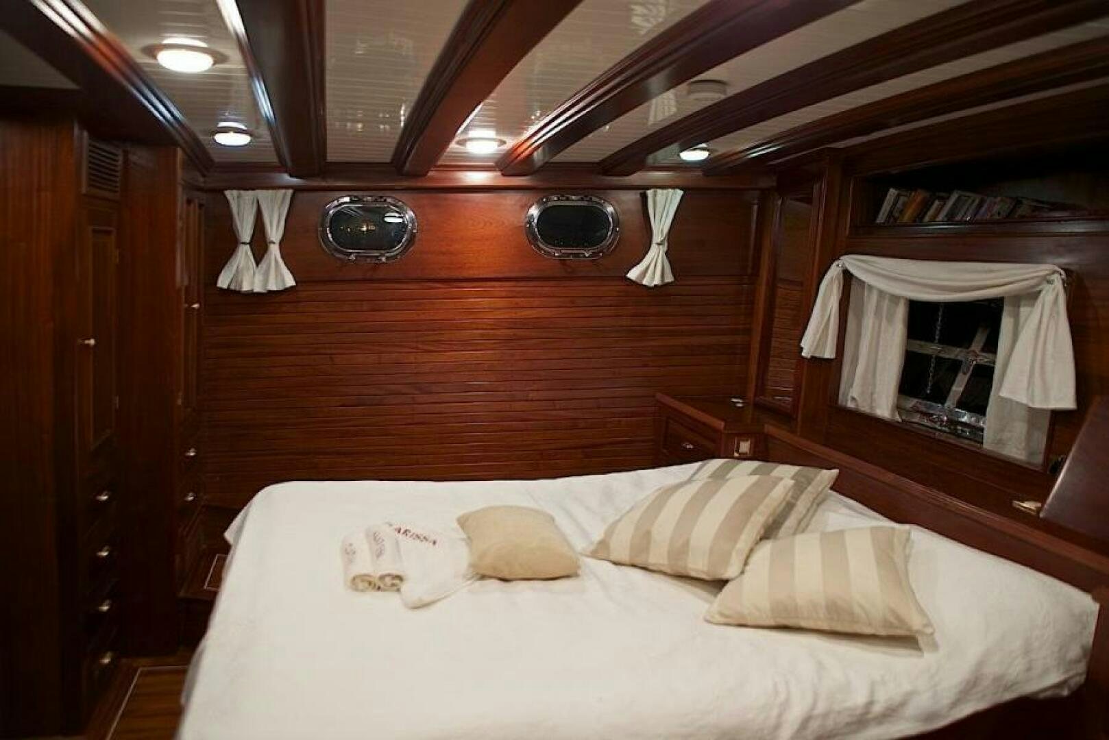 a bed with white sheets and pillows aboard CLARISSA Yacht for Sale