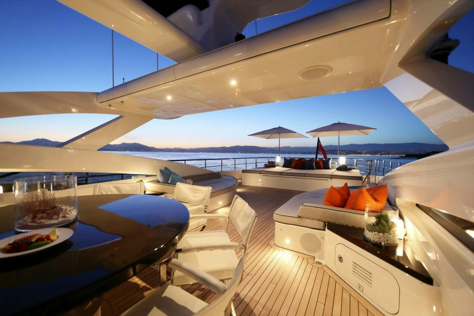 a room with a large white and blue umbrella and a table with chairs and a large umbrella on aboard AURELIA Yacht for Sale