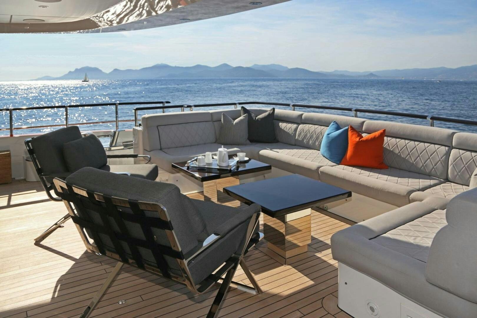 a large lounge chair on a deck overlooking a large body of water aboard AURELIA Yacht for Sale
