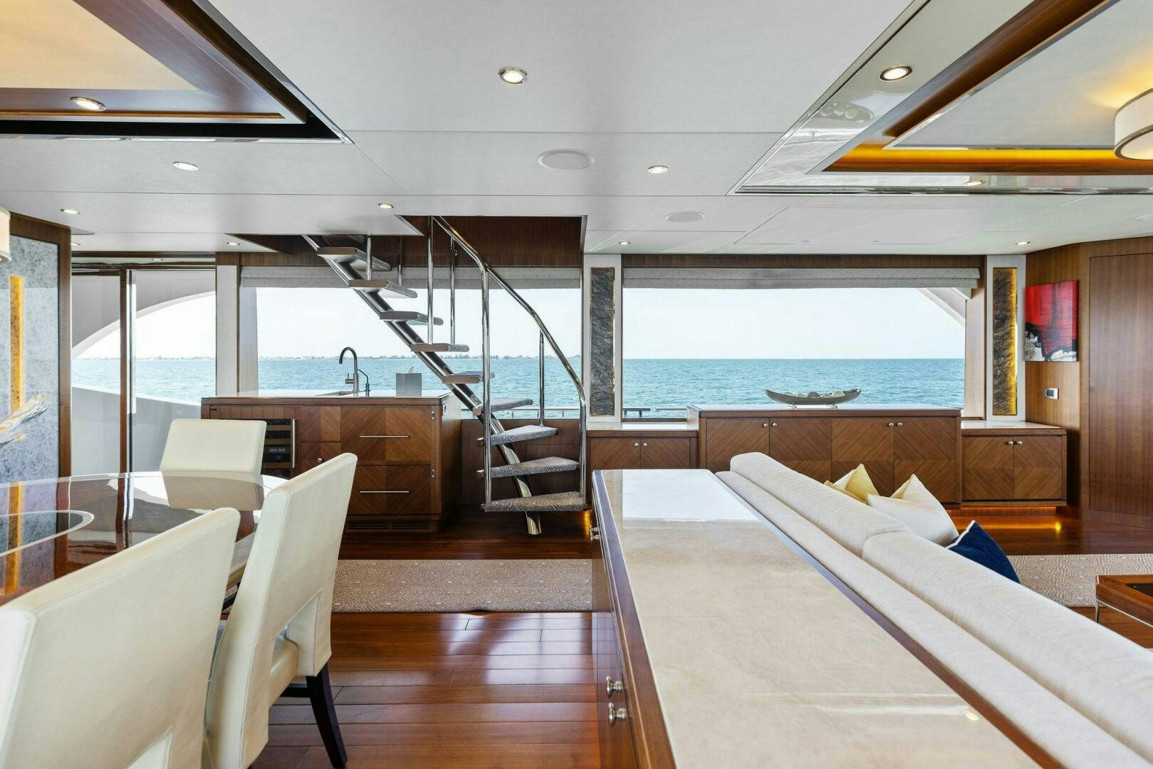 a room with a view of the ocean and a staircase aboard SUNZSET Yacht for Sale
