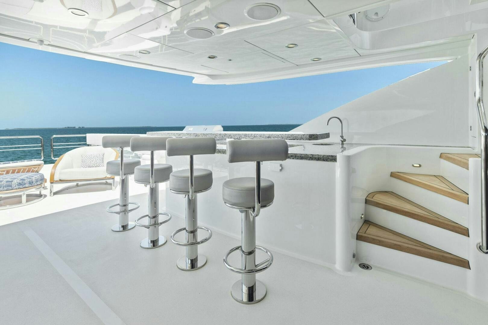 a row of stools in a room with a blue wall and a white floor aboard SUNZSET Yacht for Sale
