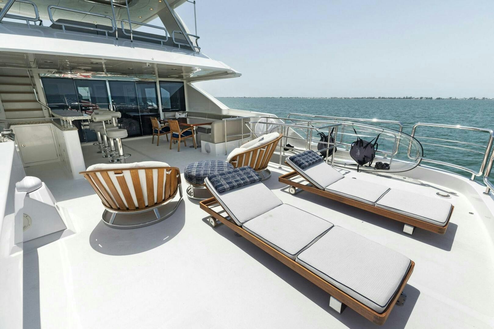 a deck with a table and chairs on it aboard SUNZSET Yacht for Sale