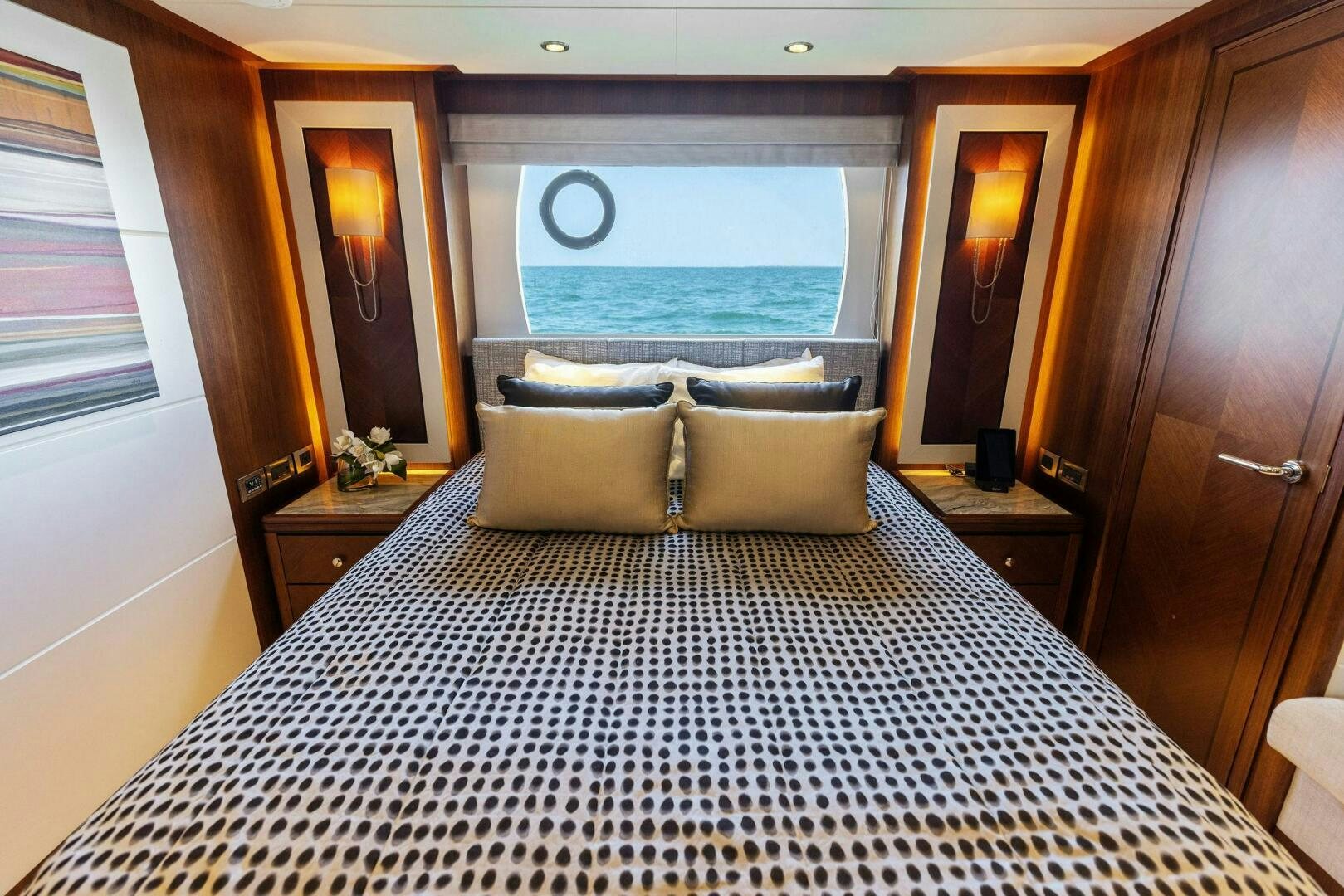 a bed with a large window aboard SUNZSET Yacht for Sale