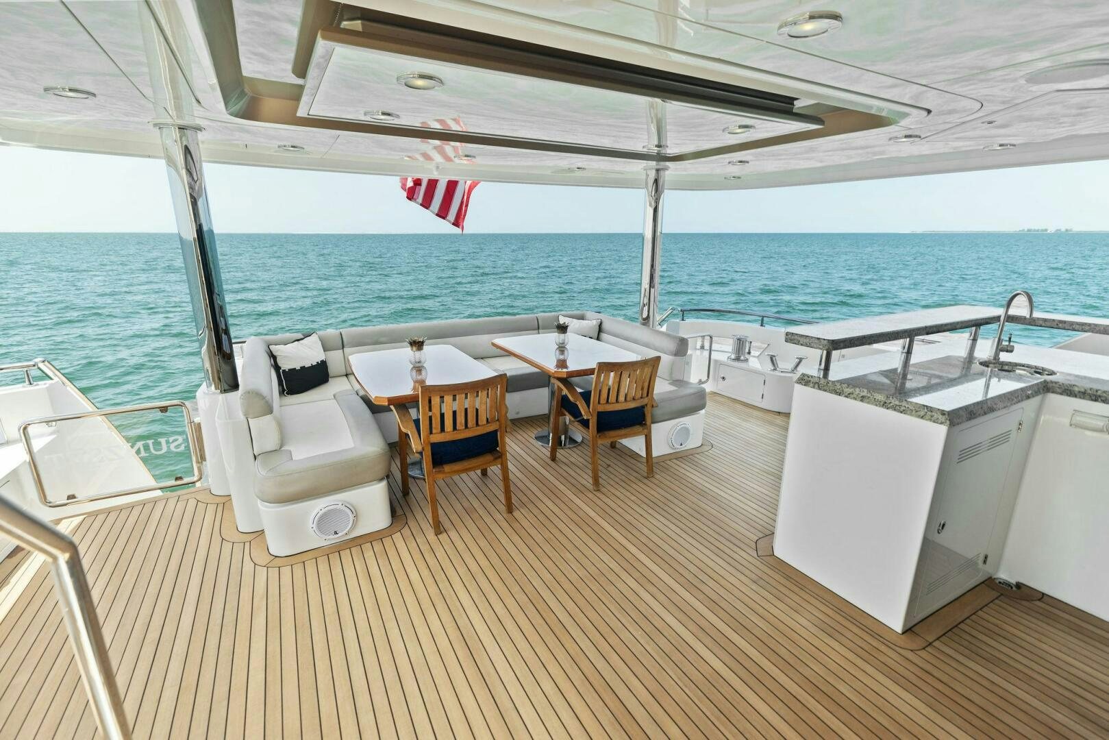 a deck with chairs and tables on it aboard SUNZSET Yacht for Sale