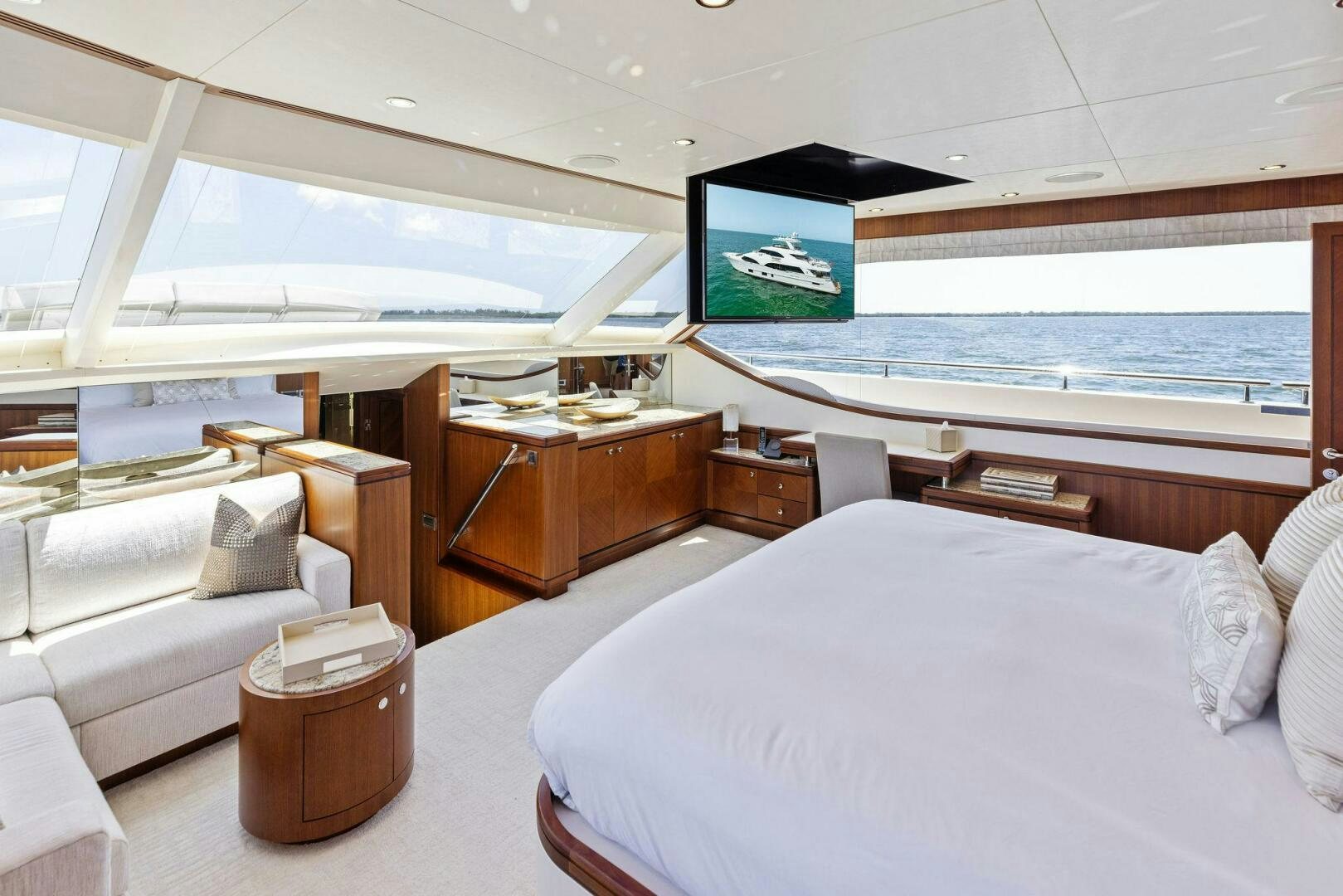 a room with a bed and a television on the wall aboard SUNZSET Yacht for Sale
