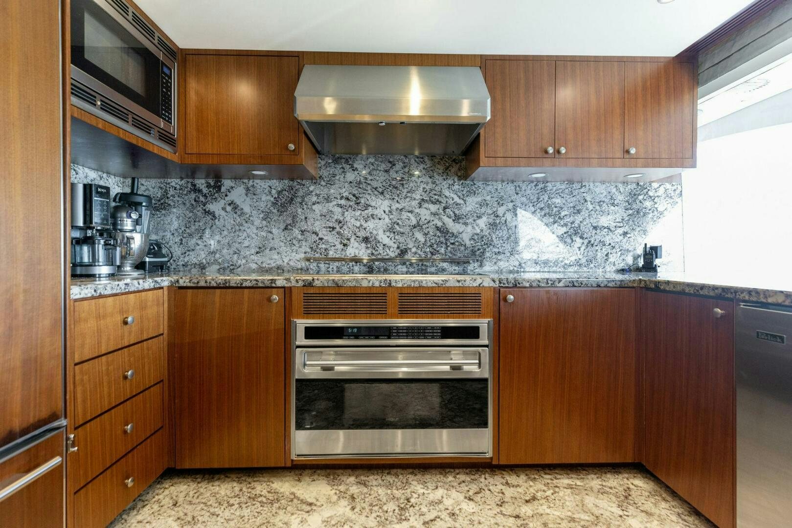 a kitchen with wooden cabinets aboard SUNZSET Yacht for Sale