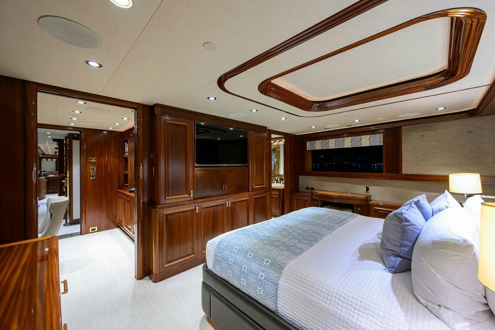 a bedroom with a bed and a wood cabinet aboard SARABETH Yacht for Sale
