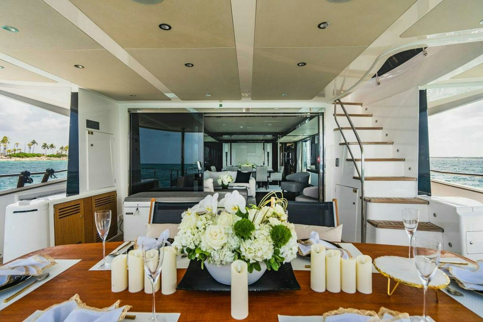 a table with white flowers and candles aboard PURA VIDA Yacht for Sale