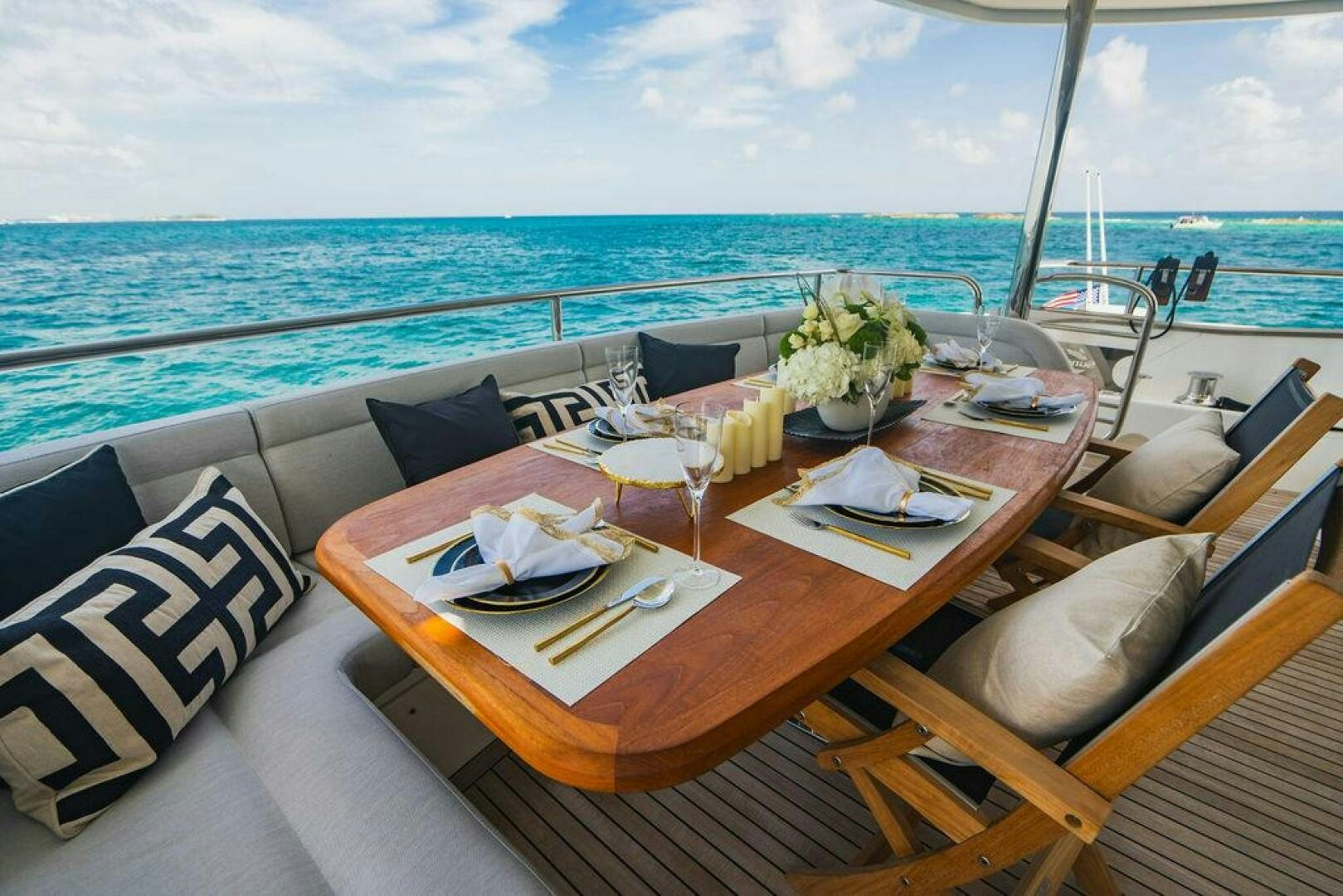 a table with plates and flowers on it on a boat aboard PURA VIDA Yacht for Sale