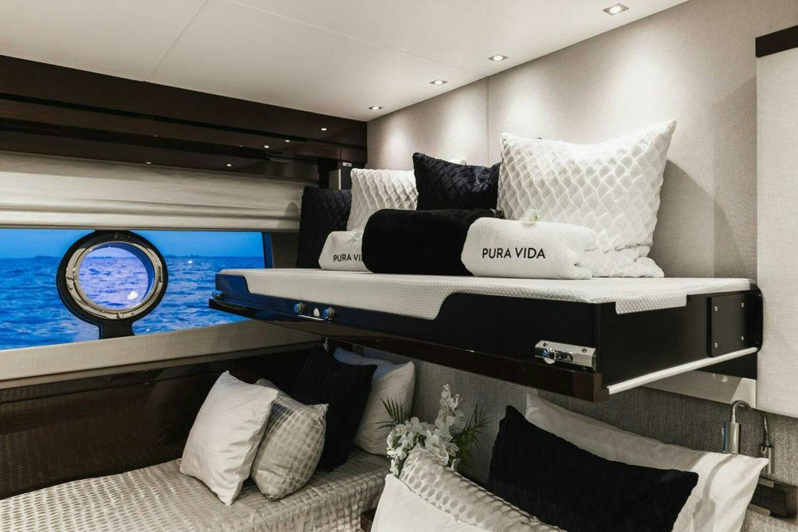 a bed with a large window aboard PURA VIDA Yacht for Sale