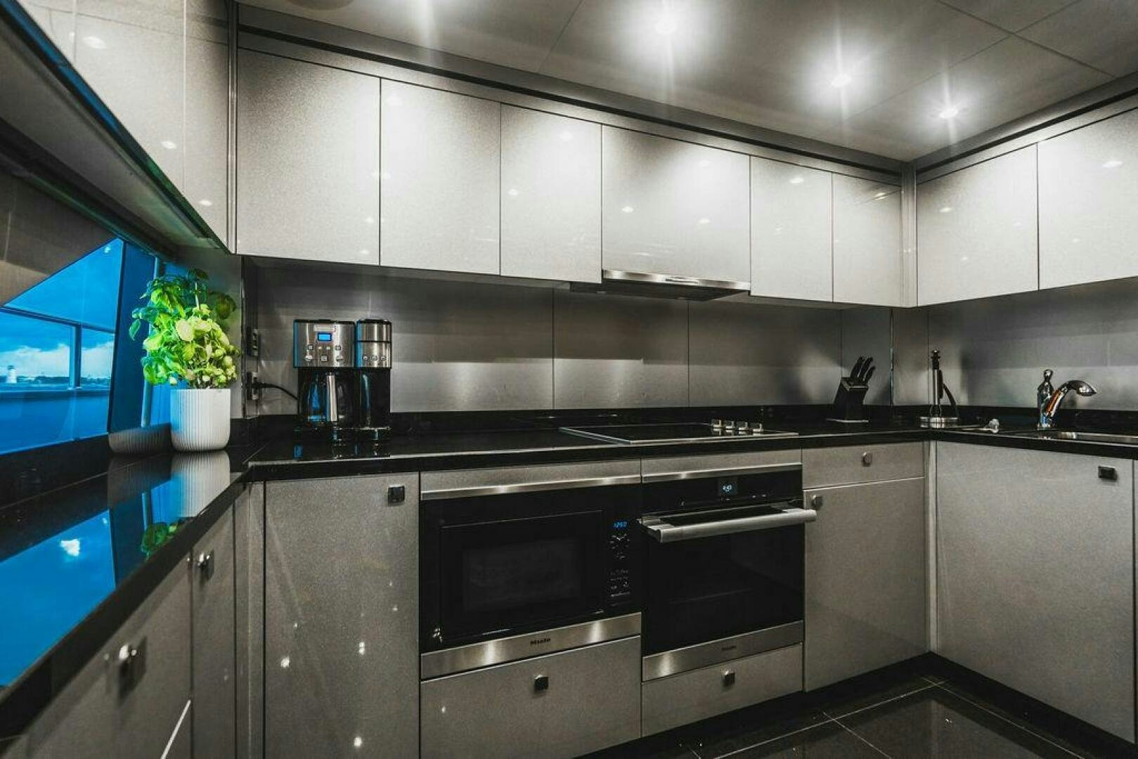 a kitchen with black appliances aboard PURA VIDA Yacht for Sale