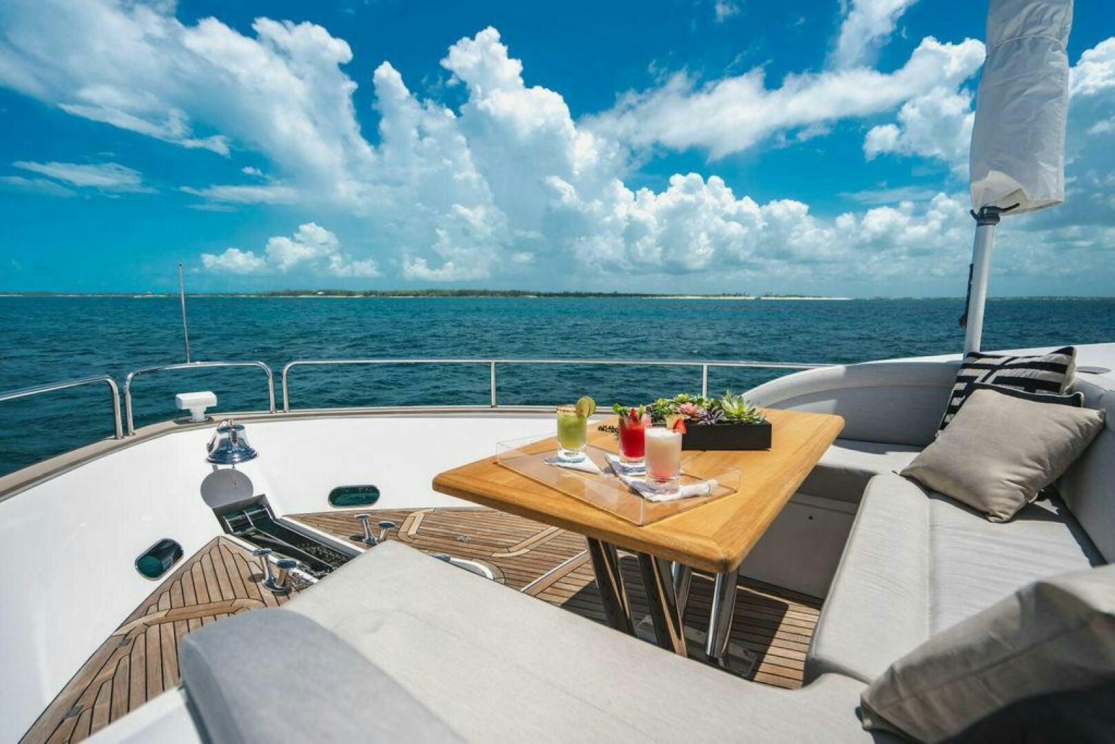 a table with chairs on it next to a large body of water aboard PURA VIDA Yacht for Sale