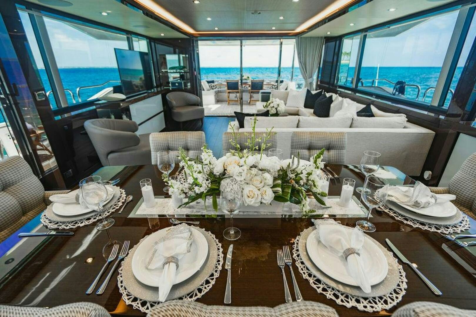 a table with plates and flowers aboard PURA VIDA Yacht for Sale
