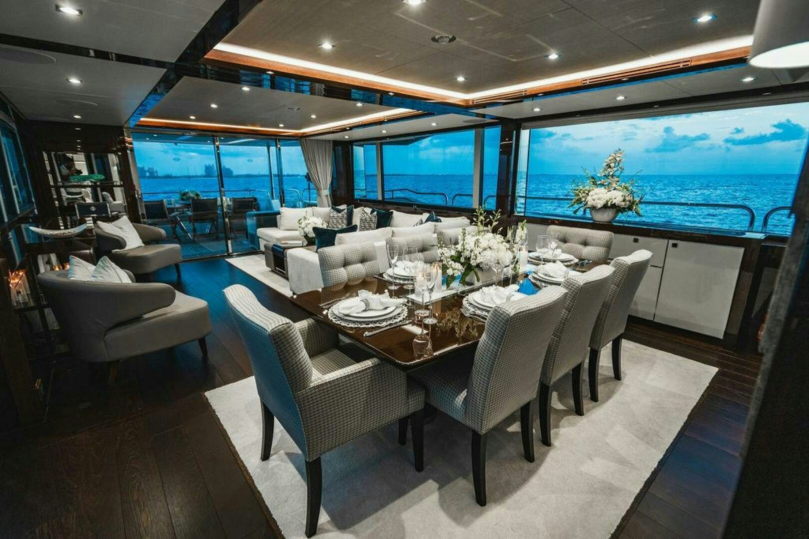 a large dining room with a large window overlooking the ocean aboard PURA VIDA Yacht for Sale