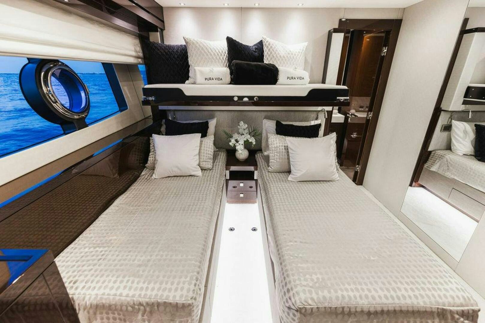 a room with a bed and a mirror aboard PURA VIDA Yacht for Sale