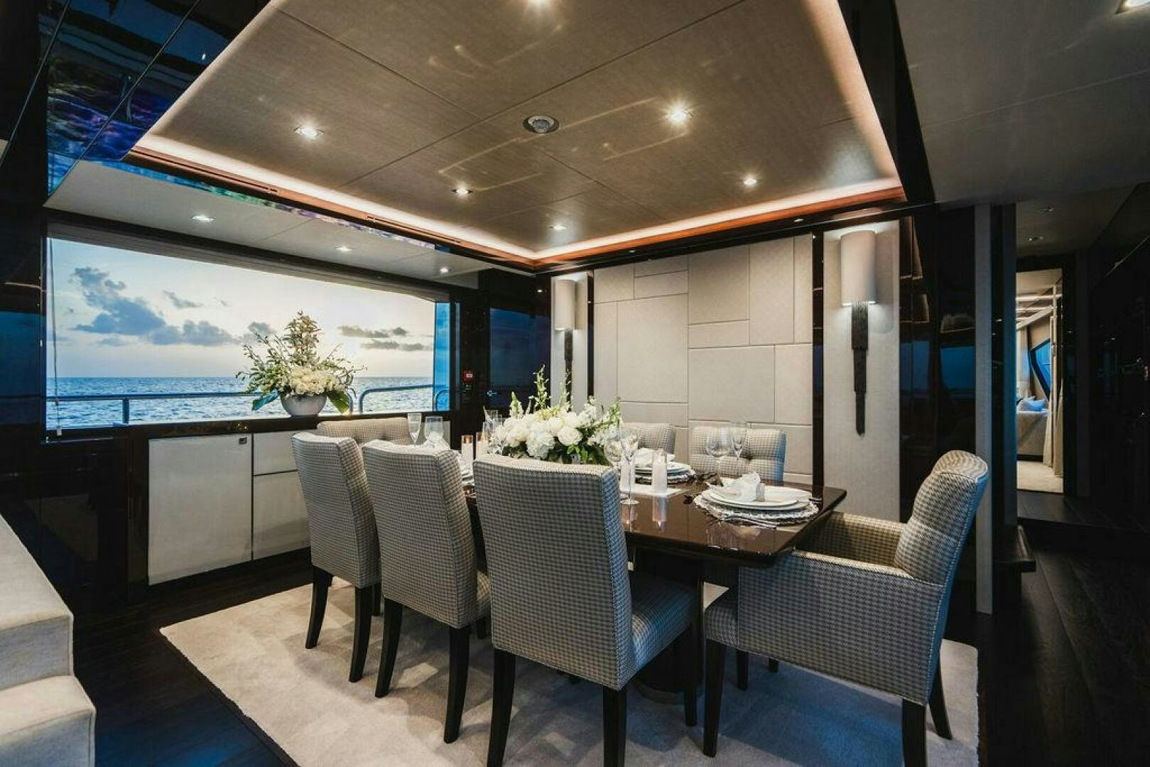 a room with a table chairs and a large window aboard PURA VIDA Yacht for Sale