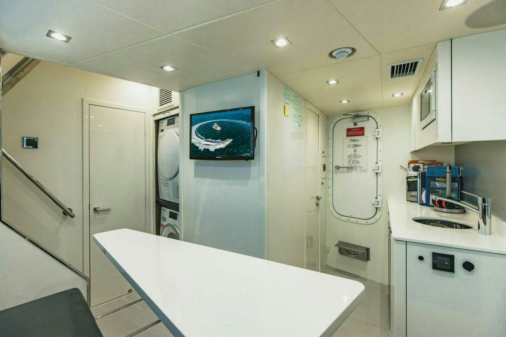 a kitchen with a table and refrigerator aboard PURA VIDA Yacht for Sale