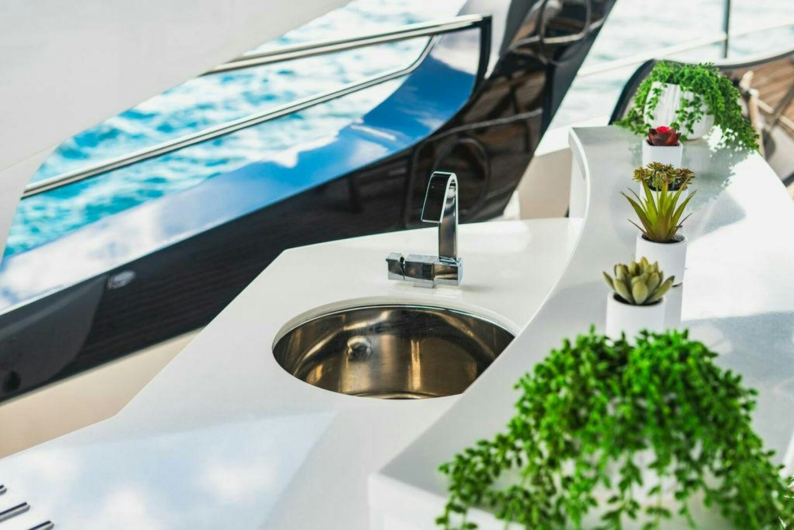 a sink with plants and a chair aboard PURA VIDA Yacht for Sale