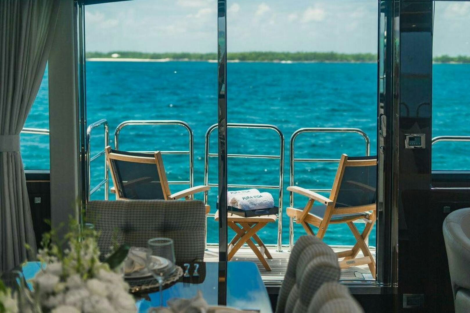 a balcony with a table and chairs aboard PURA VIDA Yacht for Sale