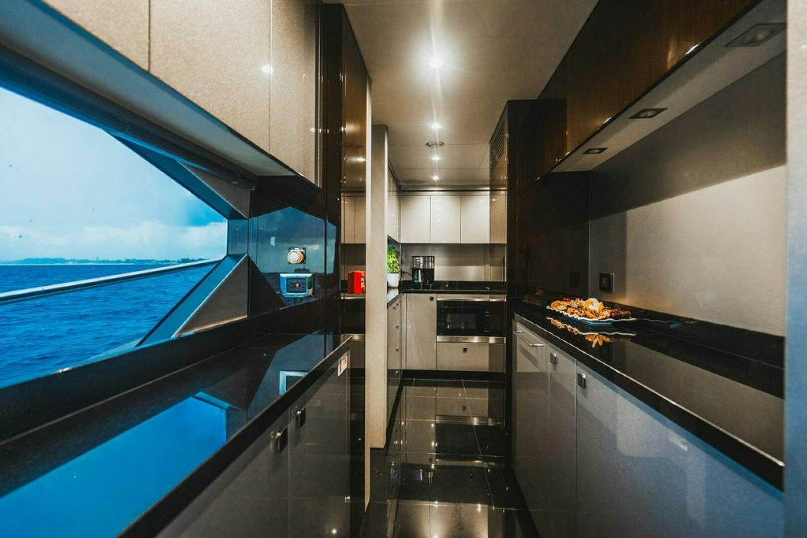 a kitchen with a large window aboard PURA VIDA Yacht for Sale