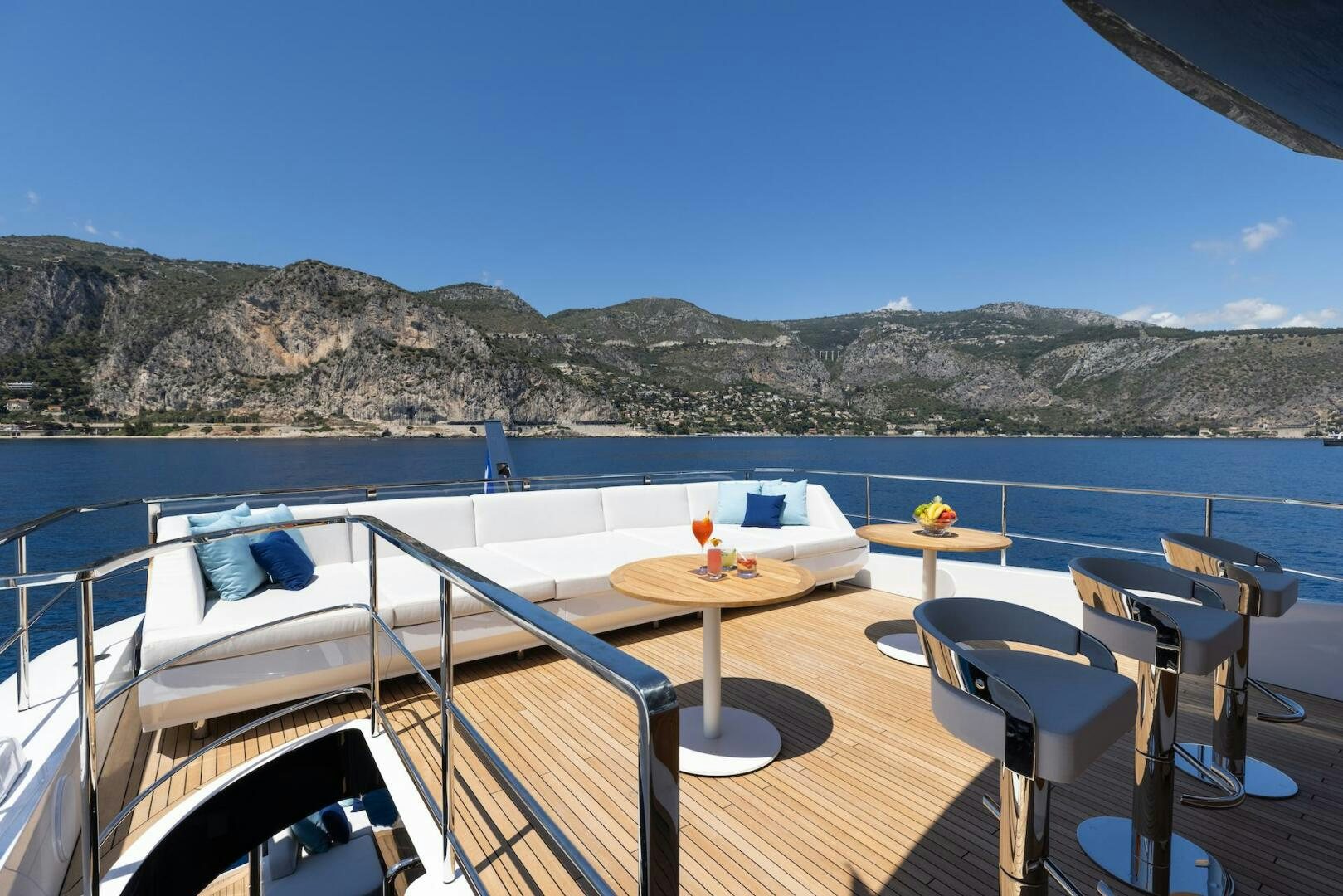 a deck with chairs and tables on it by a body of water aboard ARTEMIS Yacht for Sale
