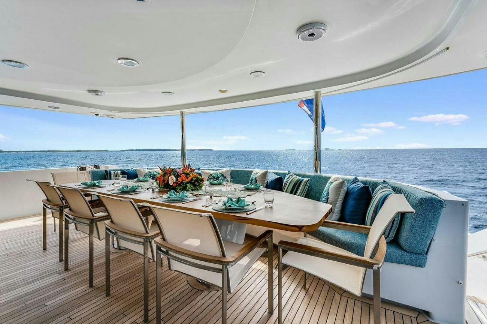 a table set for a meal on a deck overlooking the ocean aboard CUPCAKE Yacht for Sale