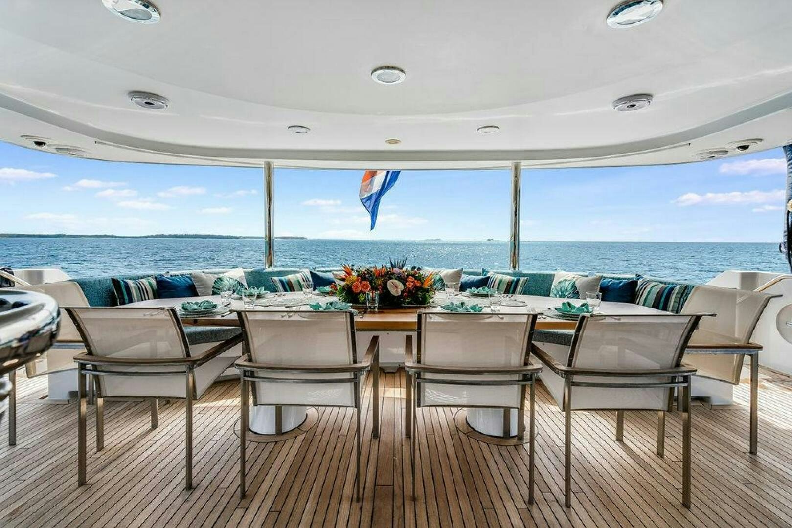 a table and chairs on a deck overlooking the ocean aboard CUPCAKE Yacht for Sale