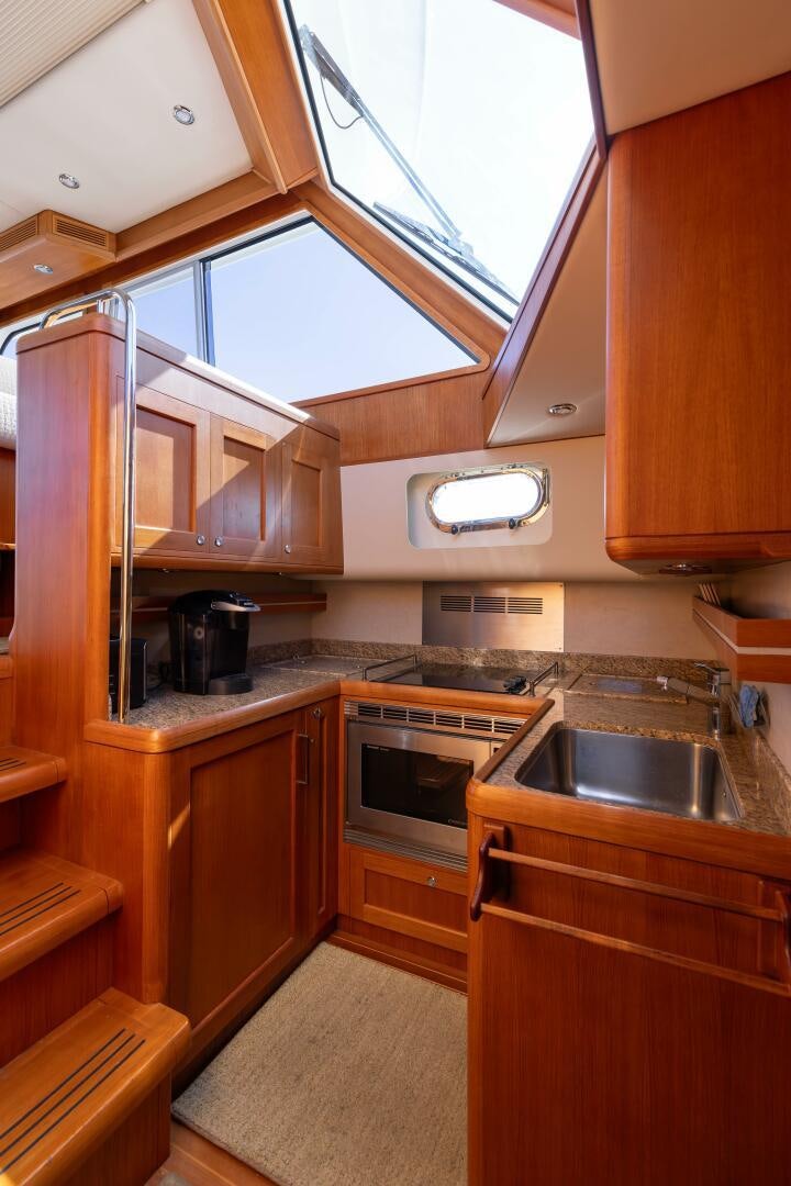 a kitchen with wooden cabinets aboard FINALLY US Yacht for Sale