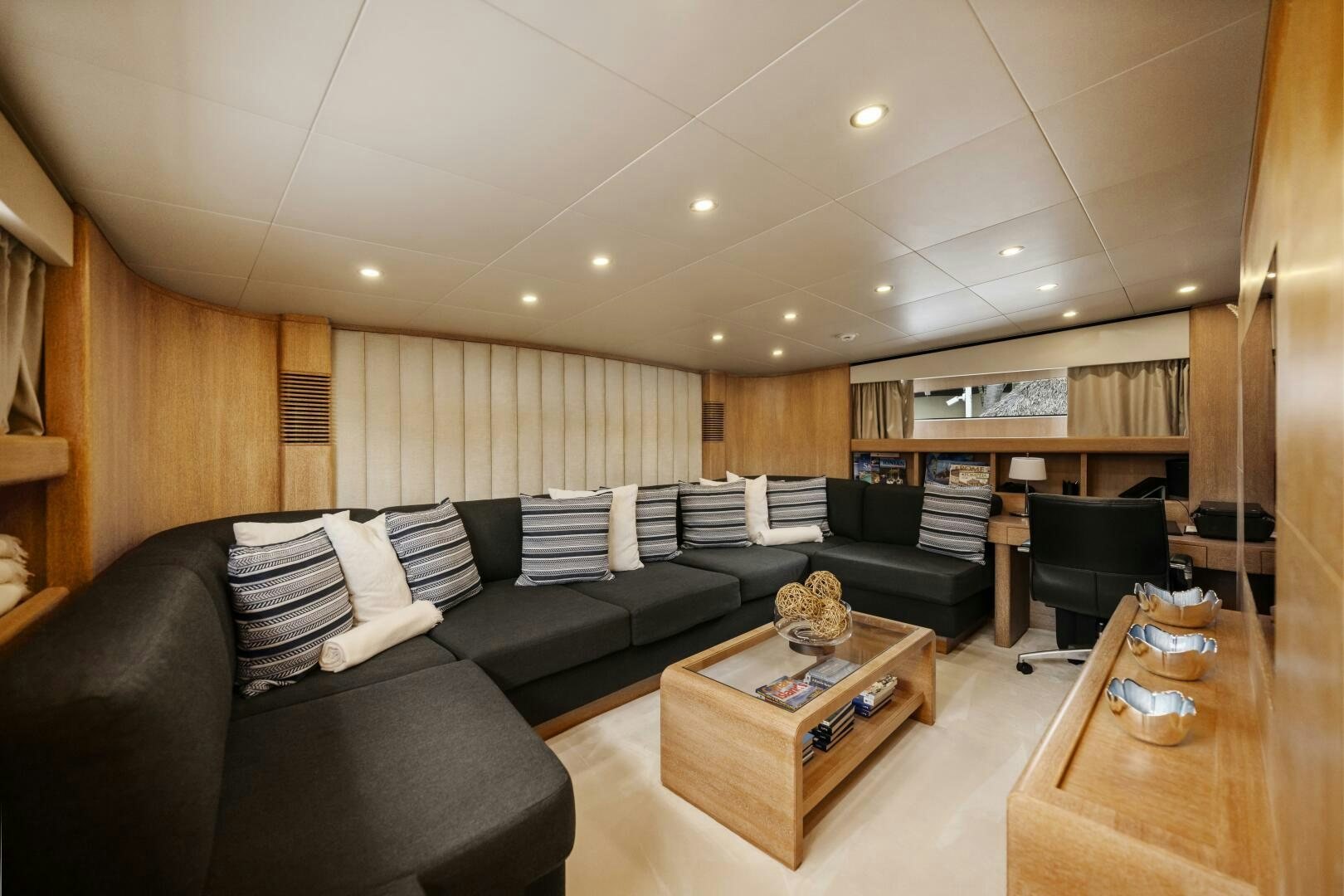 a living room with a black couch and a coffee table aboard GLADIUS Yacht for Sale