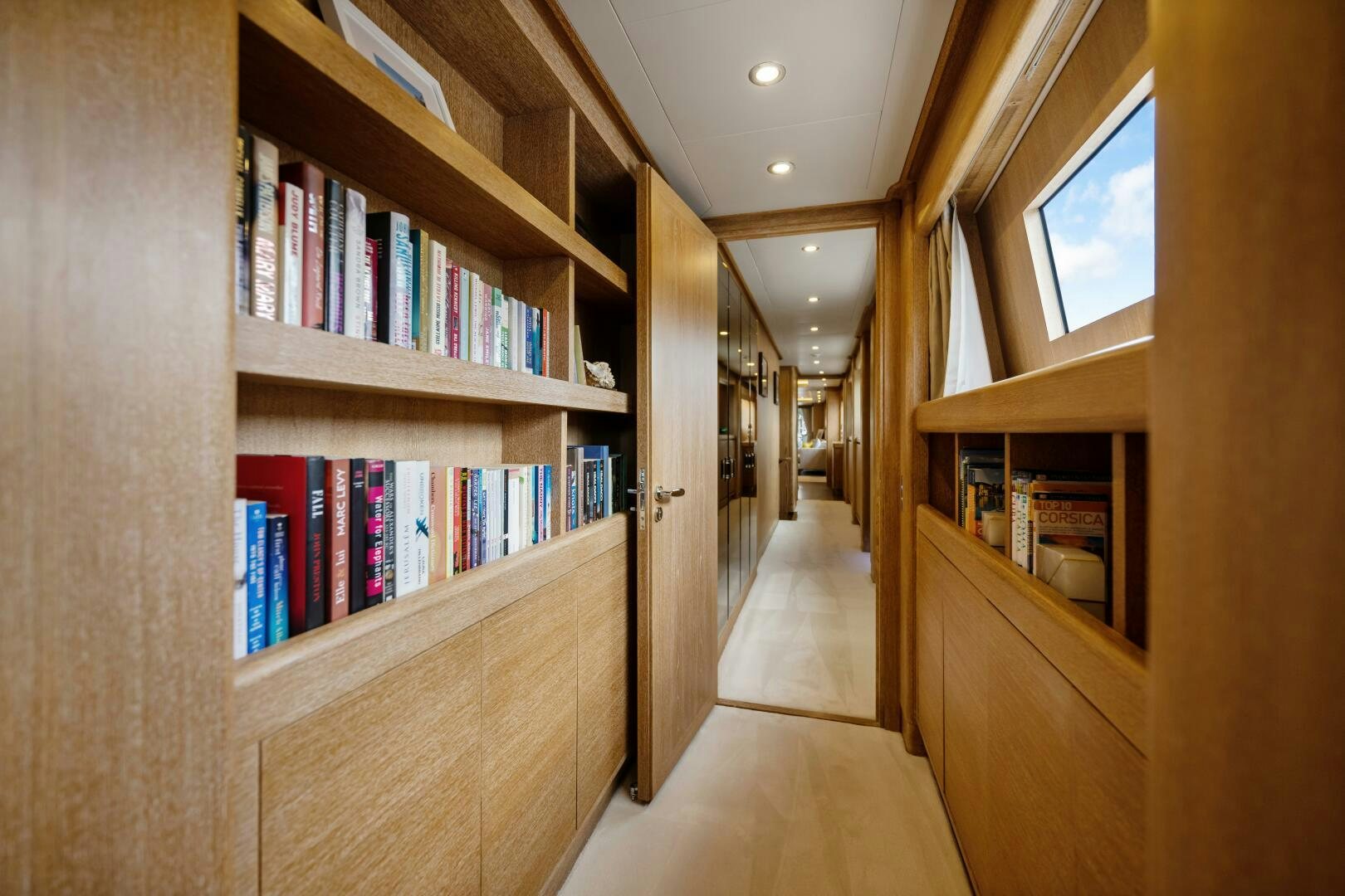 a hallway with bookshelves aboard GLADIUS Yacht for Sale