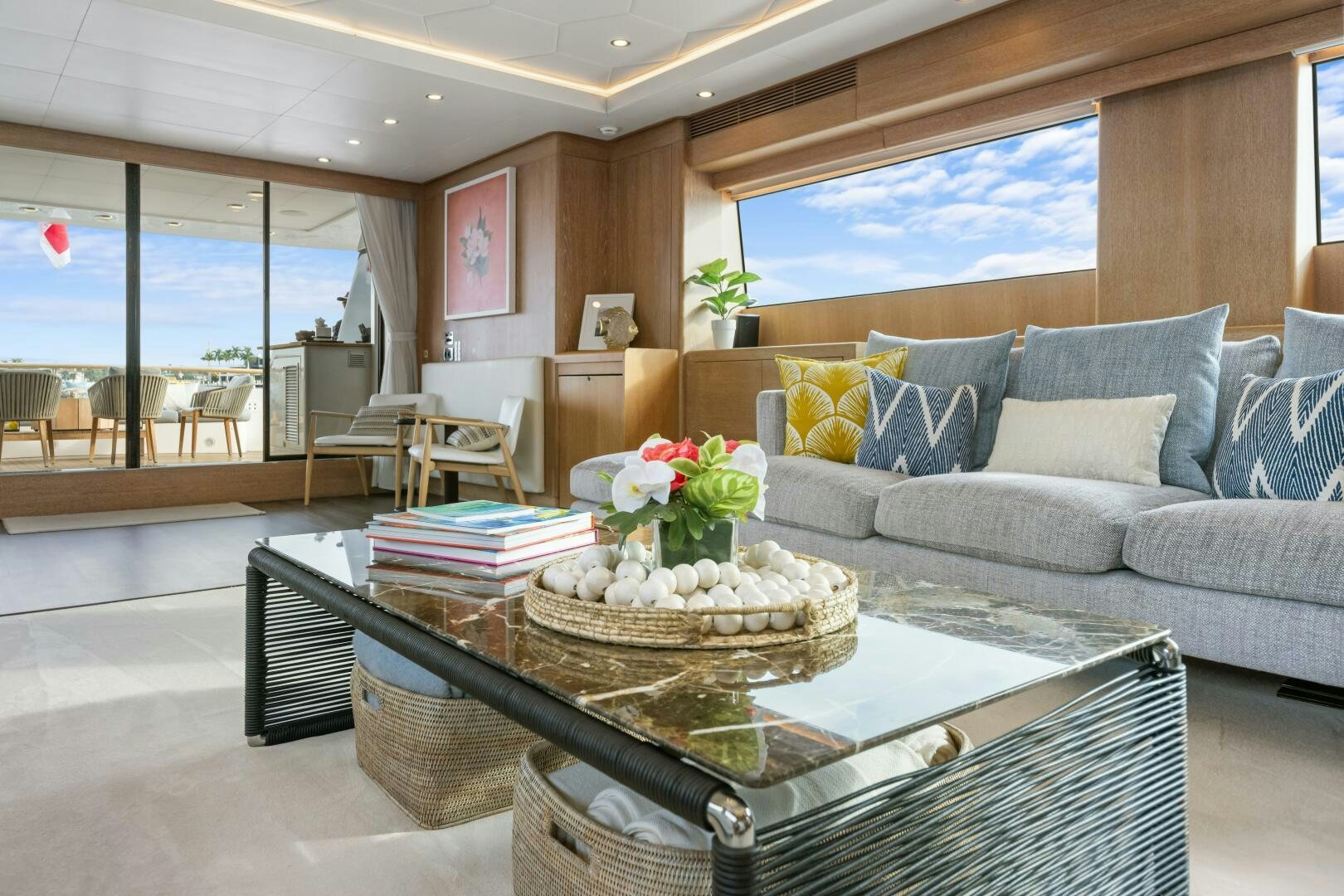 a living room with a large sofa and a table with a basket of flowers on it aboard GLADIUS Yacht for Sale