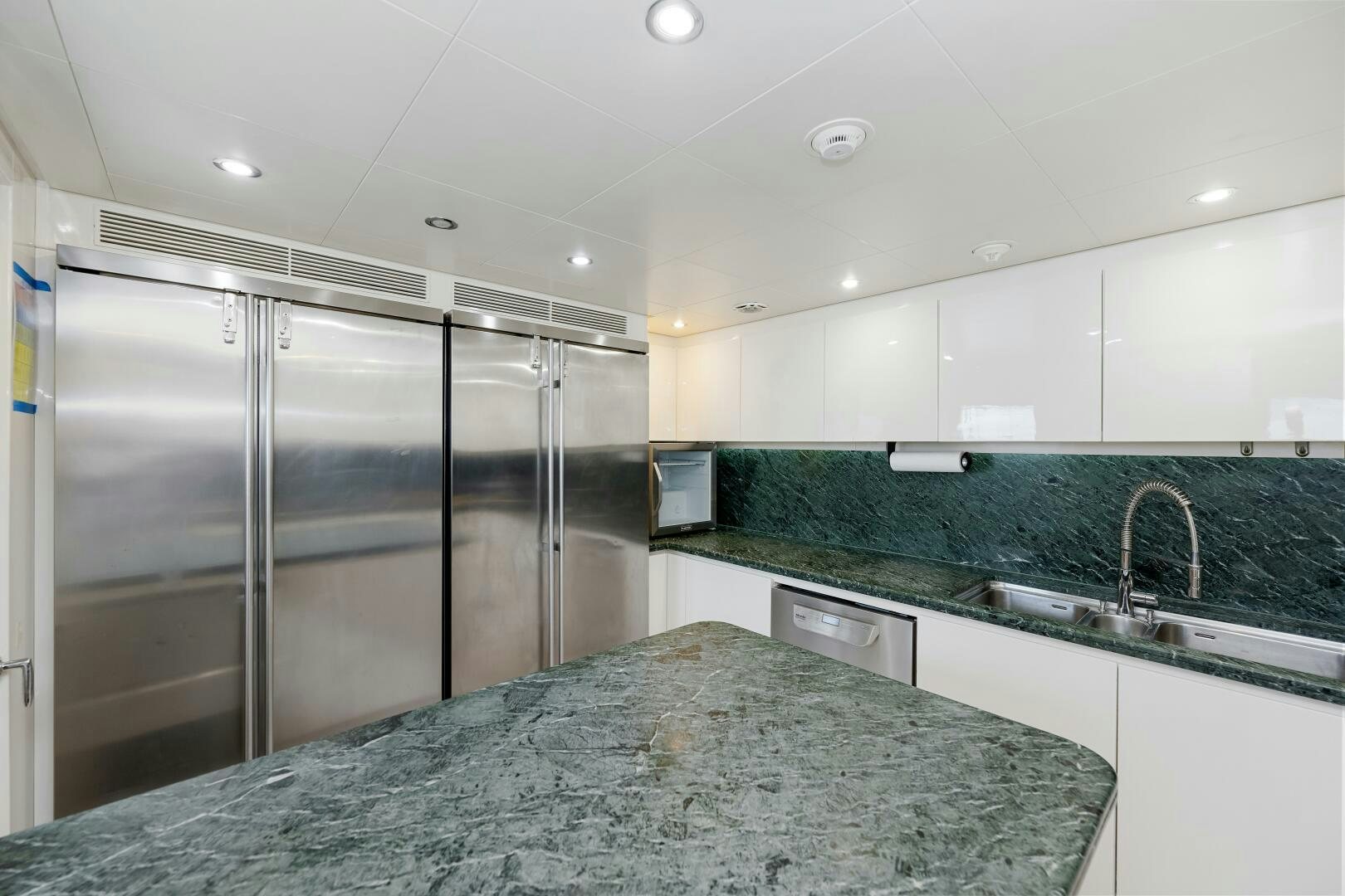 a kitchen with a stainless steel refrigerator aboard GLADIUS Yacht for Sale