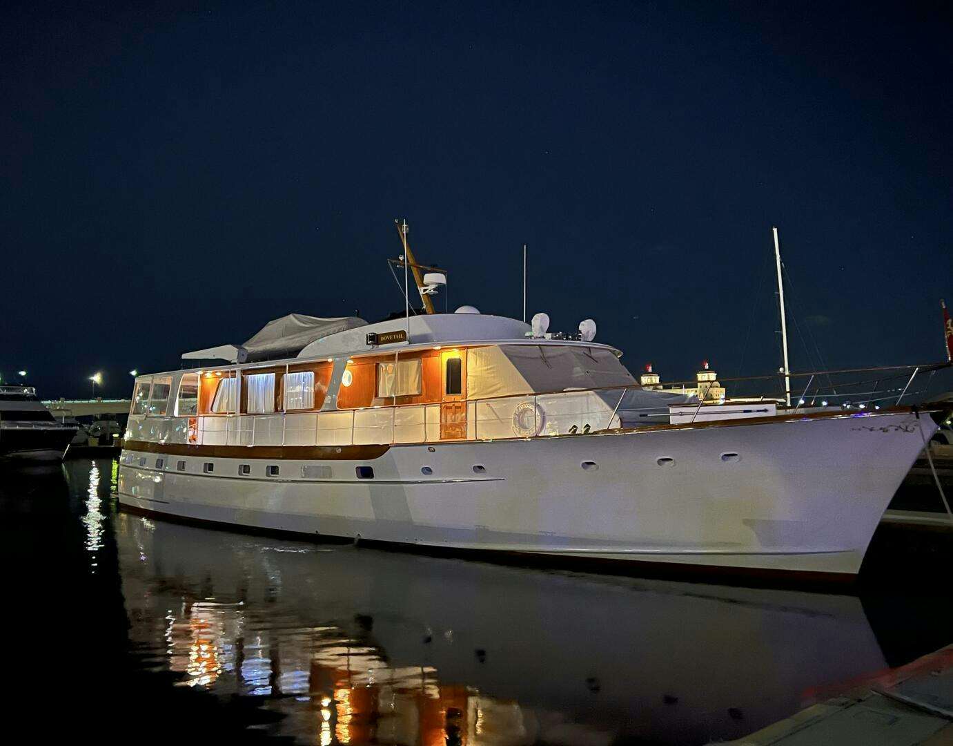 a large white boat in a harbor aboard DOVETAIL Yacht for Sale