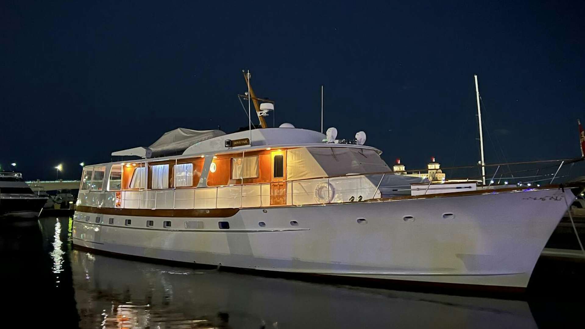 a large white boat in a harbor aboard DOVETAIL Yacht for Sale