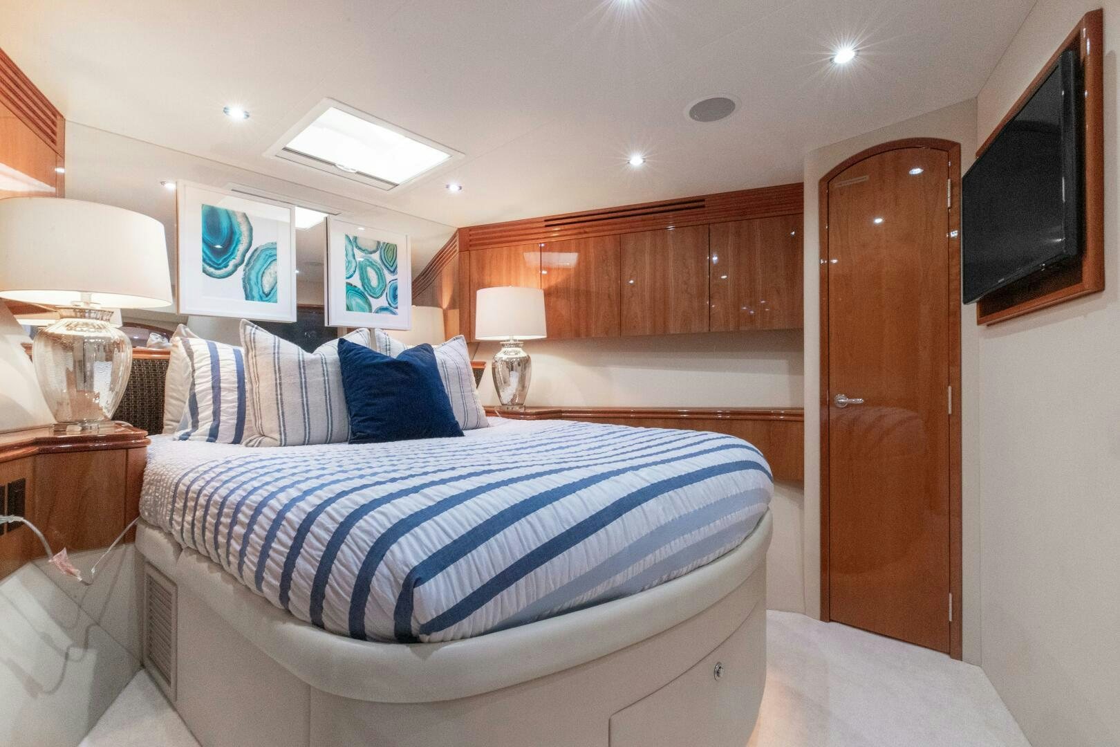 a bedroom with a bed and a wood cabinet aboard PIRATE RADIO Yacht for Sale