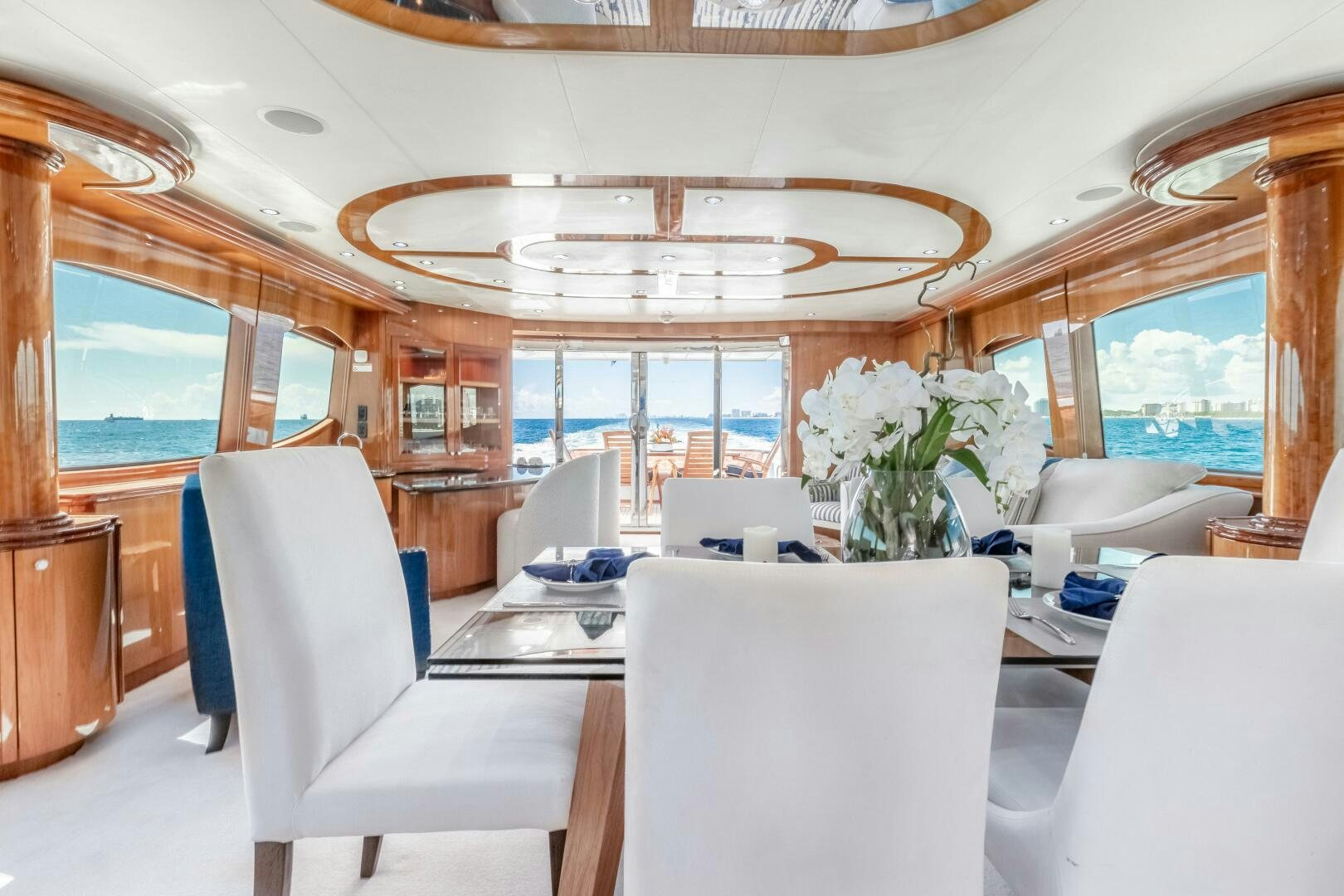 a room with a large chandelier and a table with chairs aboard PIRATE RADIO Yacht for Sale