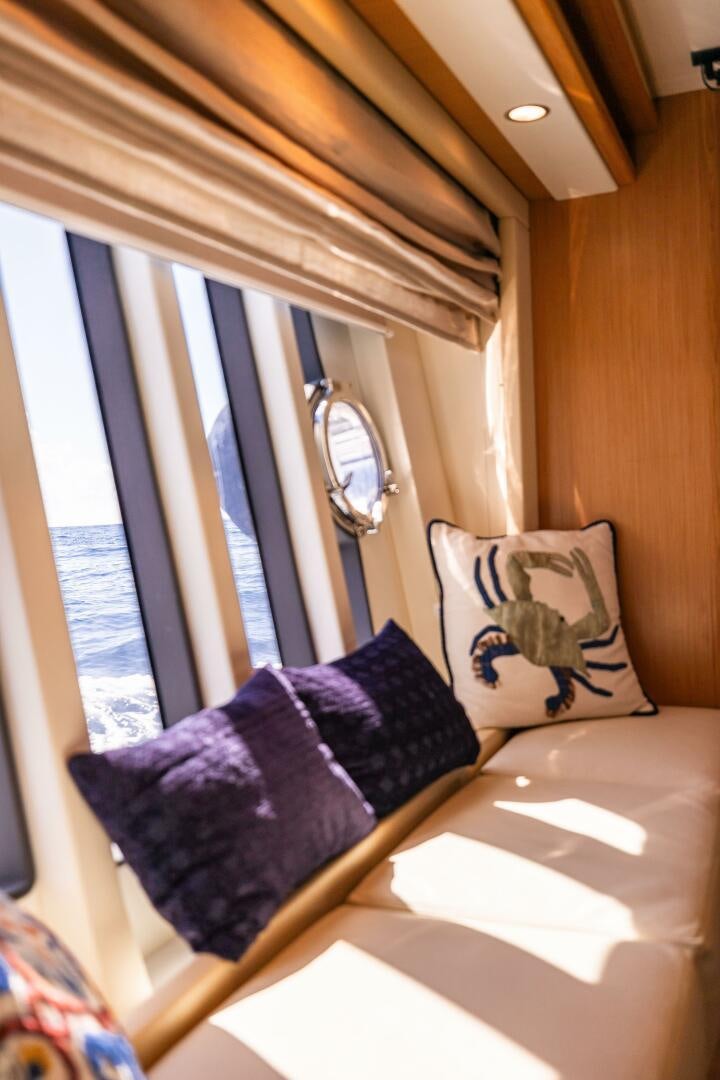 a bed with pillows and a window aboard CRYSTAL PARROT Yacht for Sale