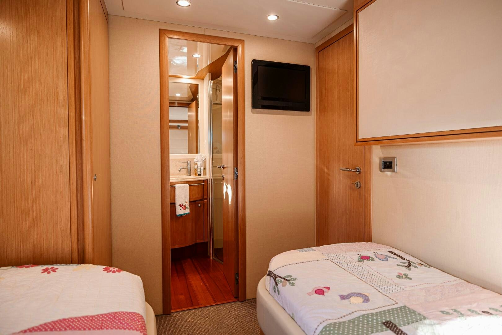a bedroom with a bed and a television aboard CRYSTAL PARROT Yacht for Sale