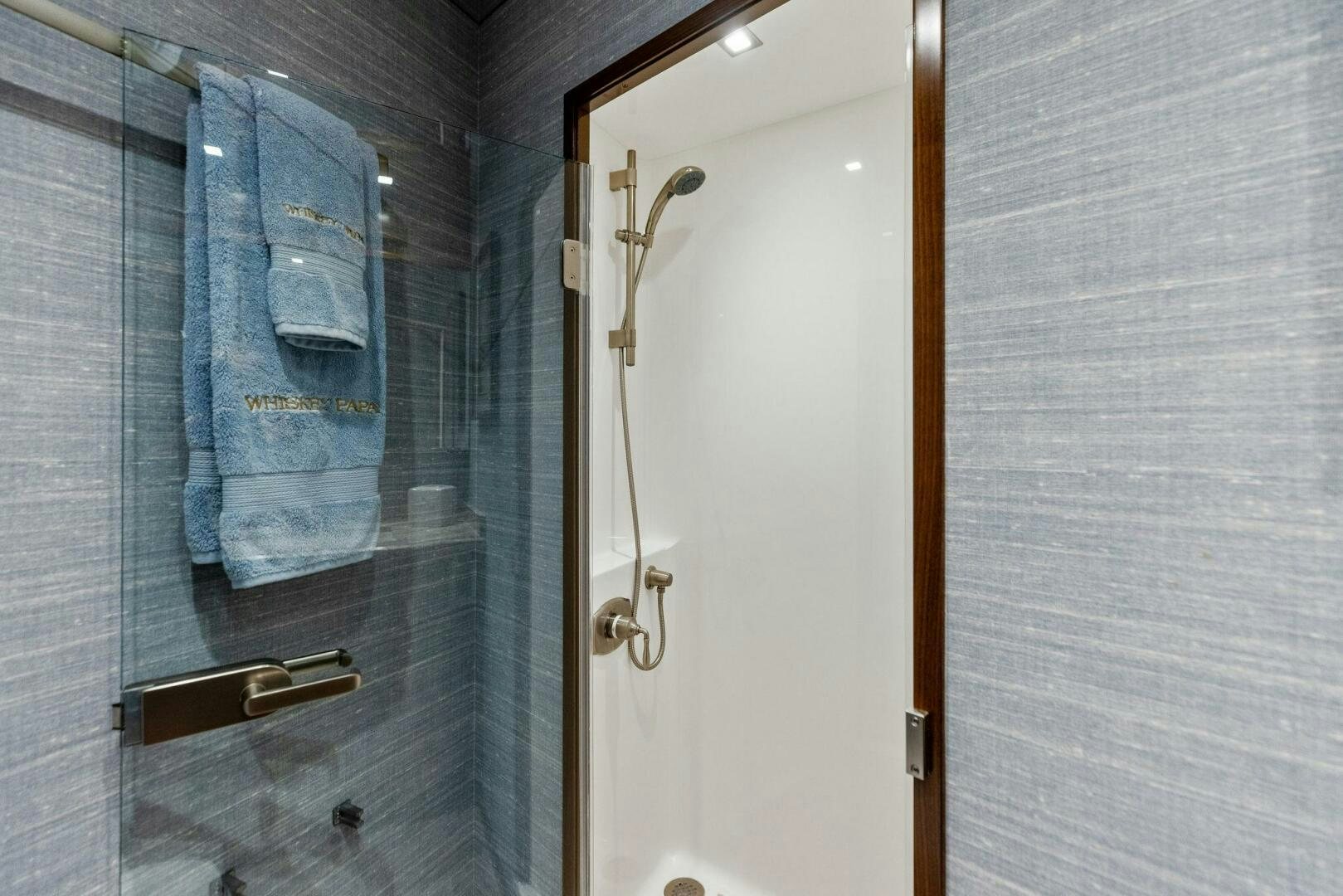 a bathroom with a blue shower curtain aboard WHISKEY PAPA Yacht for Sale