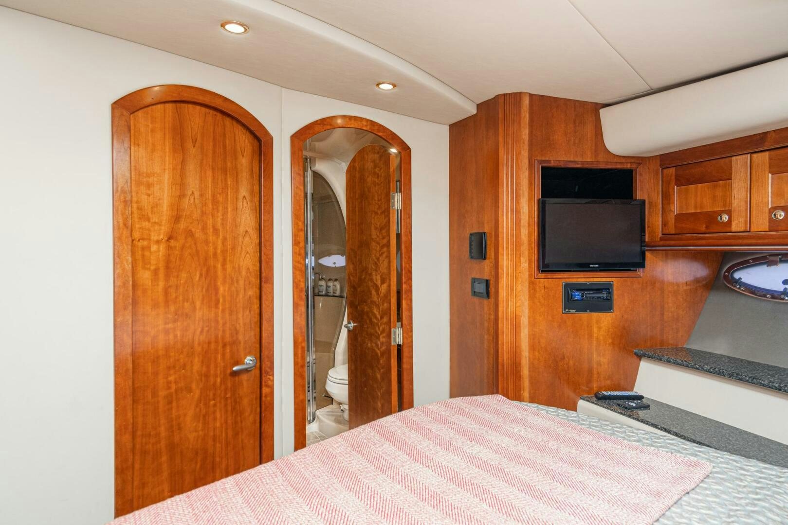 a room with a bed and a television aboard MYSTIQUE Yacht for Sale