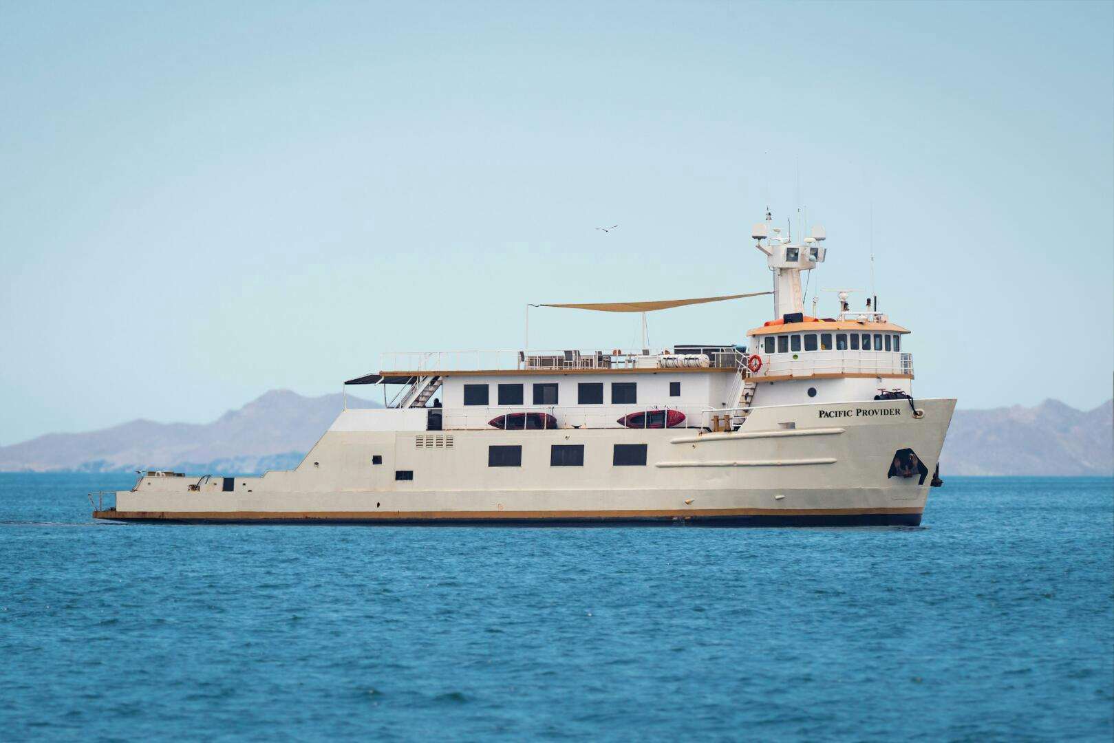 a large white ship in the water aboard PACIFIC PROVIDER Yacht for Sale