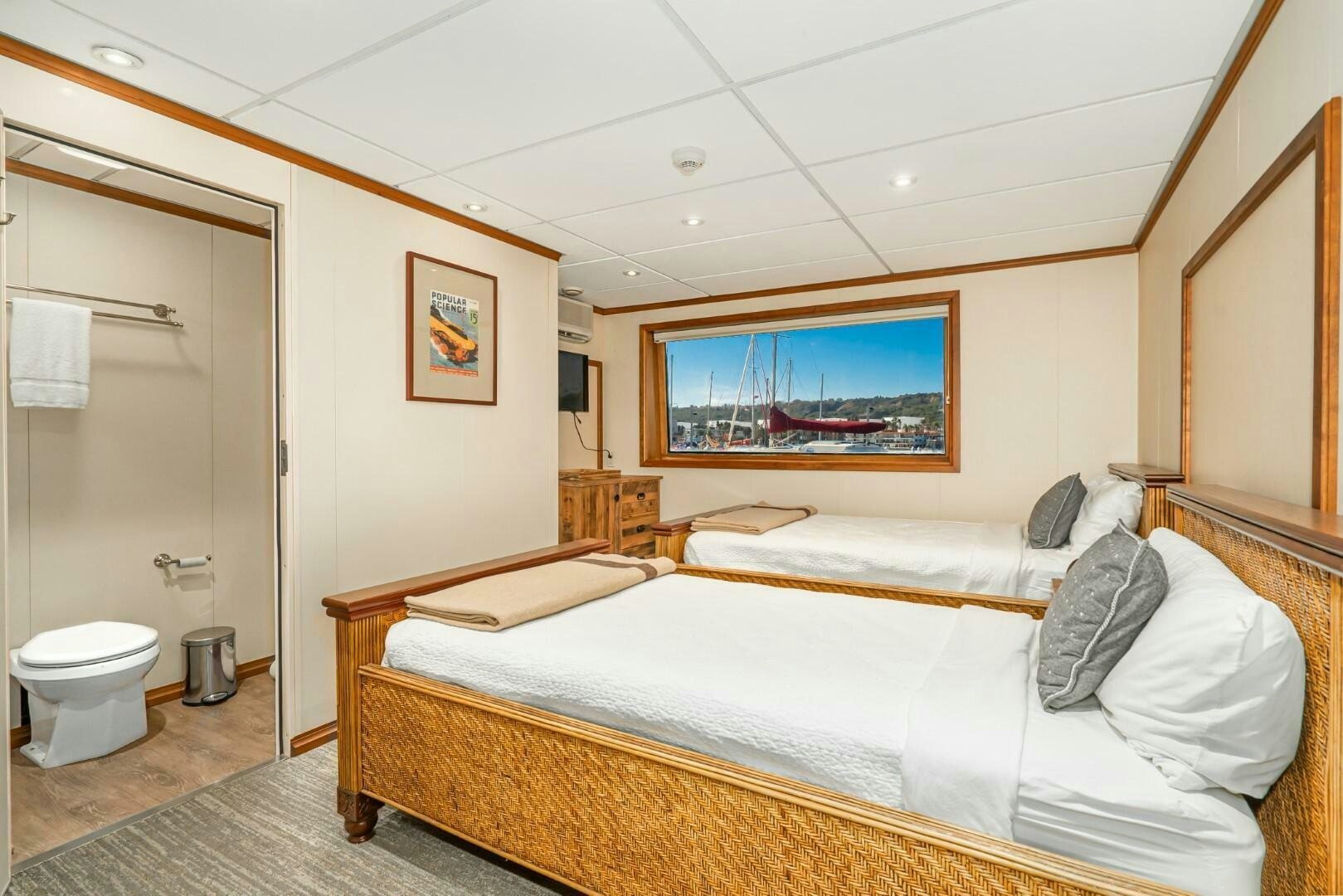 a room with a bed and a painting on the wall aboard PACIFIC PROVIDER Yacht for Sale