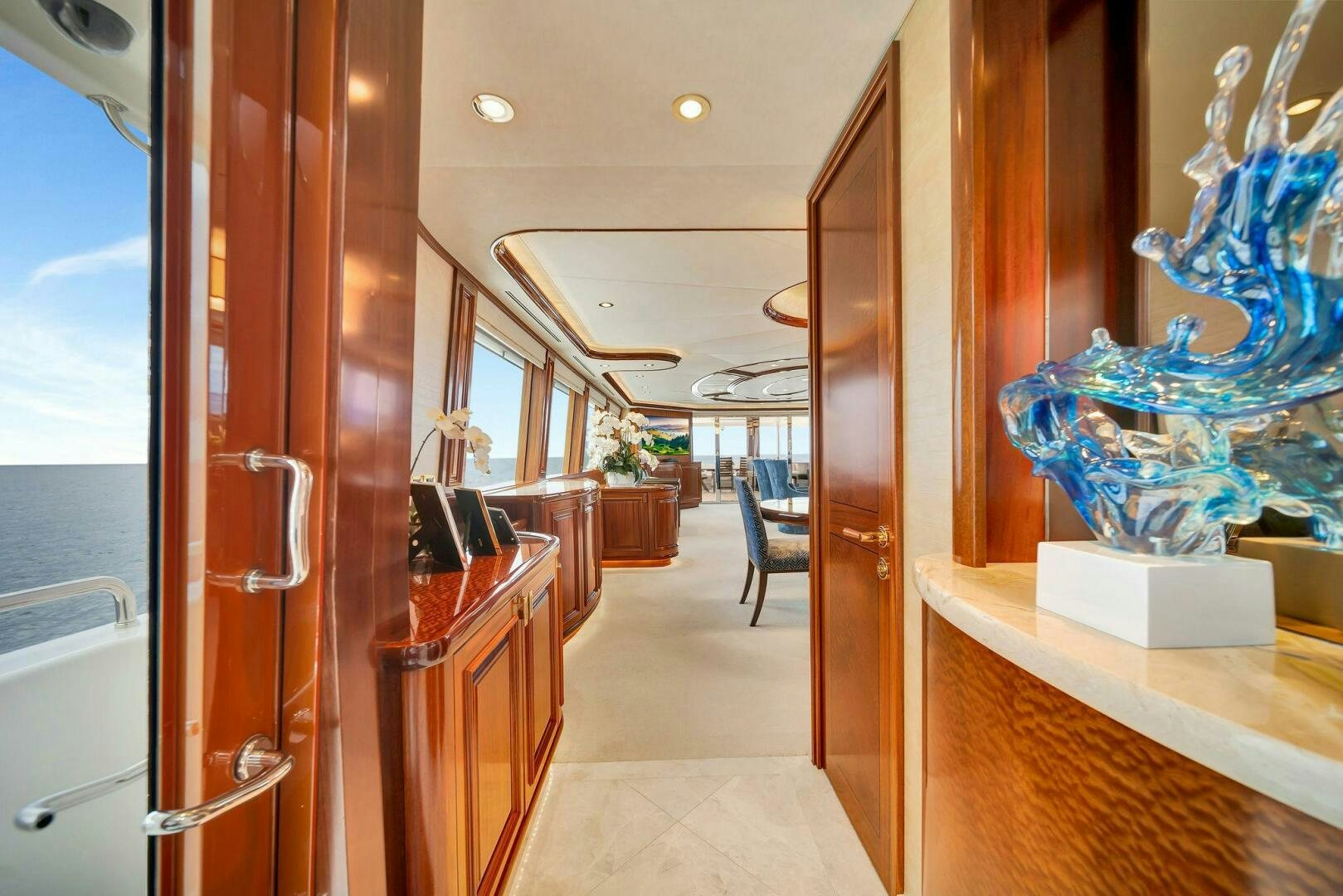 inside of a building with a glass door and a large blue vase on the table aboard JEANNIETINI NAME RESERVED Yacht for Sale