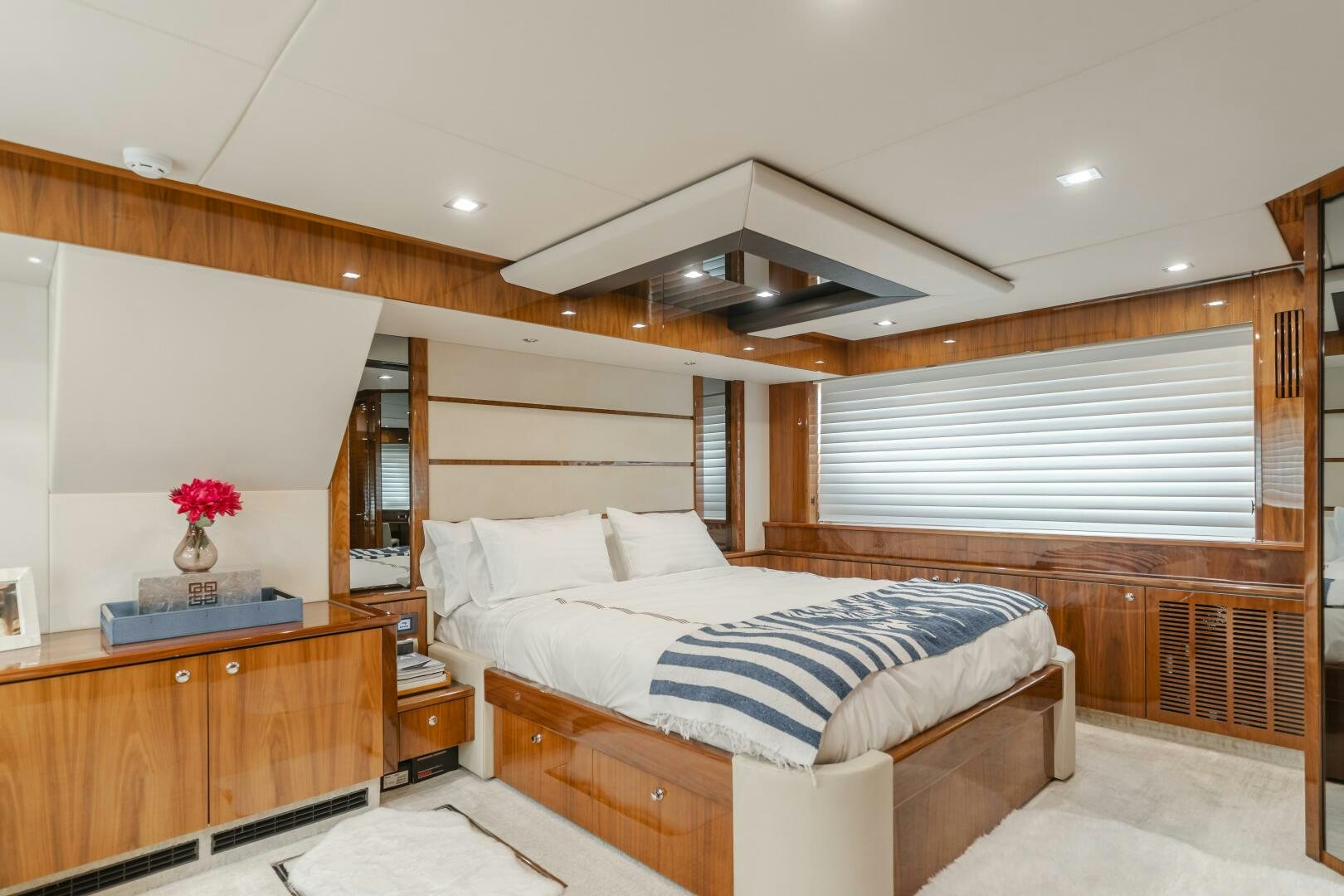 a bedroom with a bed and a wood wall aboard INDECENT PROPOSAL IV Yacht for Sale