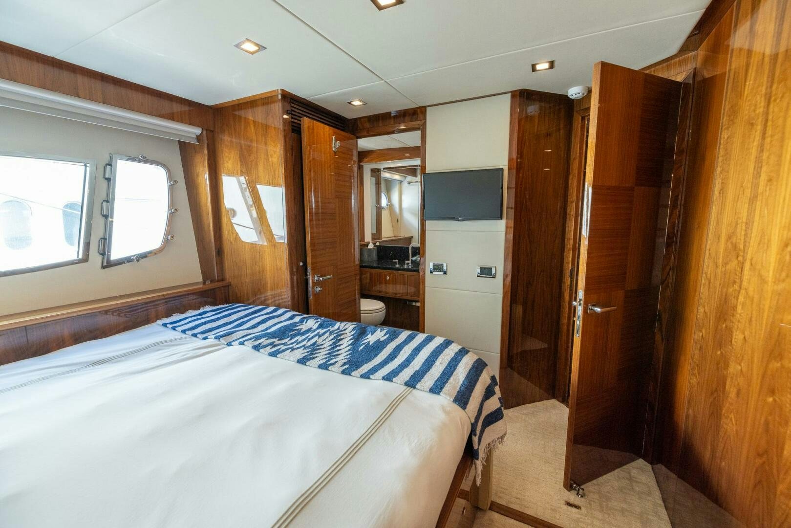 a bedroom with a bed aboard INDECENT PROPOSAL IV Yacht for Sale