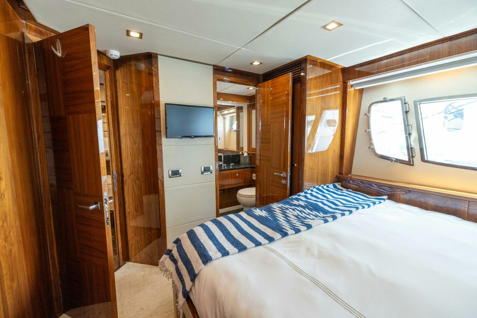 a bedroom with a bed and a closet aboard INDECENT PROPOSAL IV Yacht for Sale