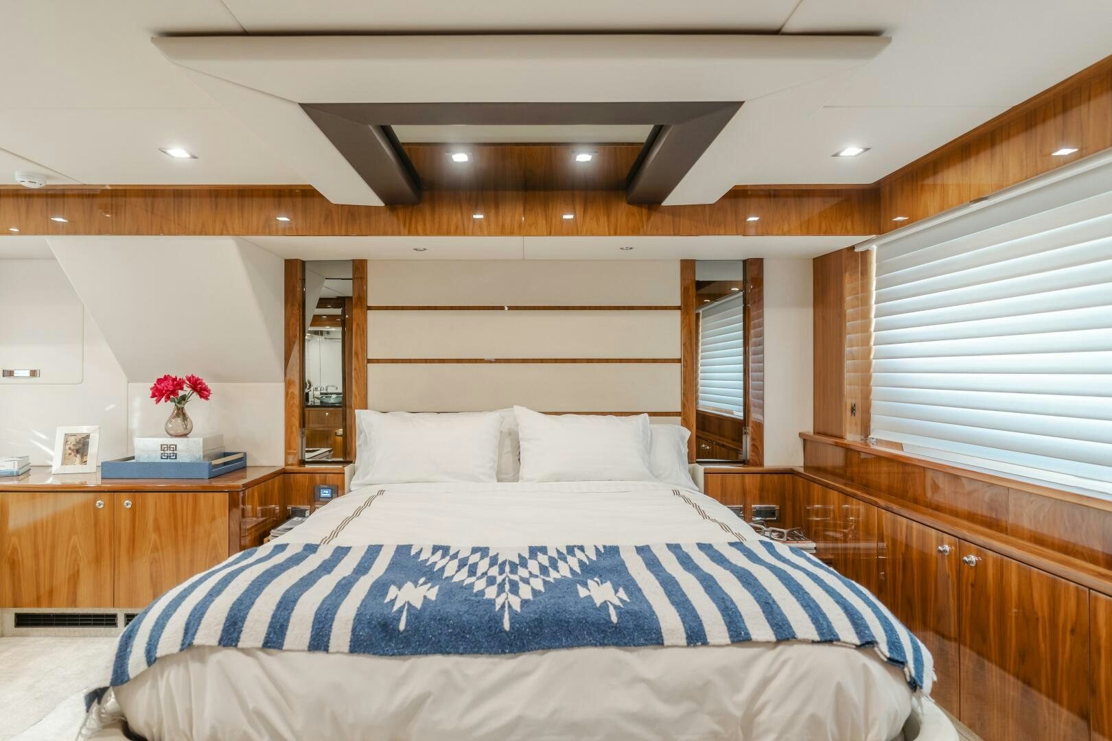 a bed with a blue and white sheet and a white pillow aboard INDECENT PROPOSAL IV Yacht for Sale