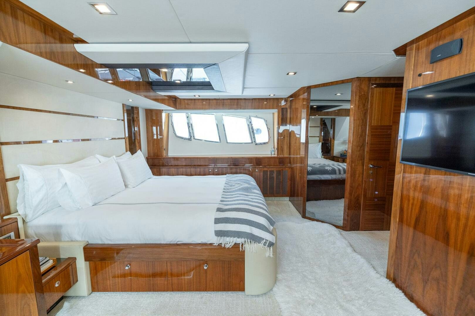 a bedroom with a bed and a television aboard INDECENT PROPOSAL IV Yacht for Sale