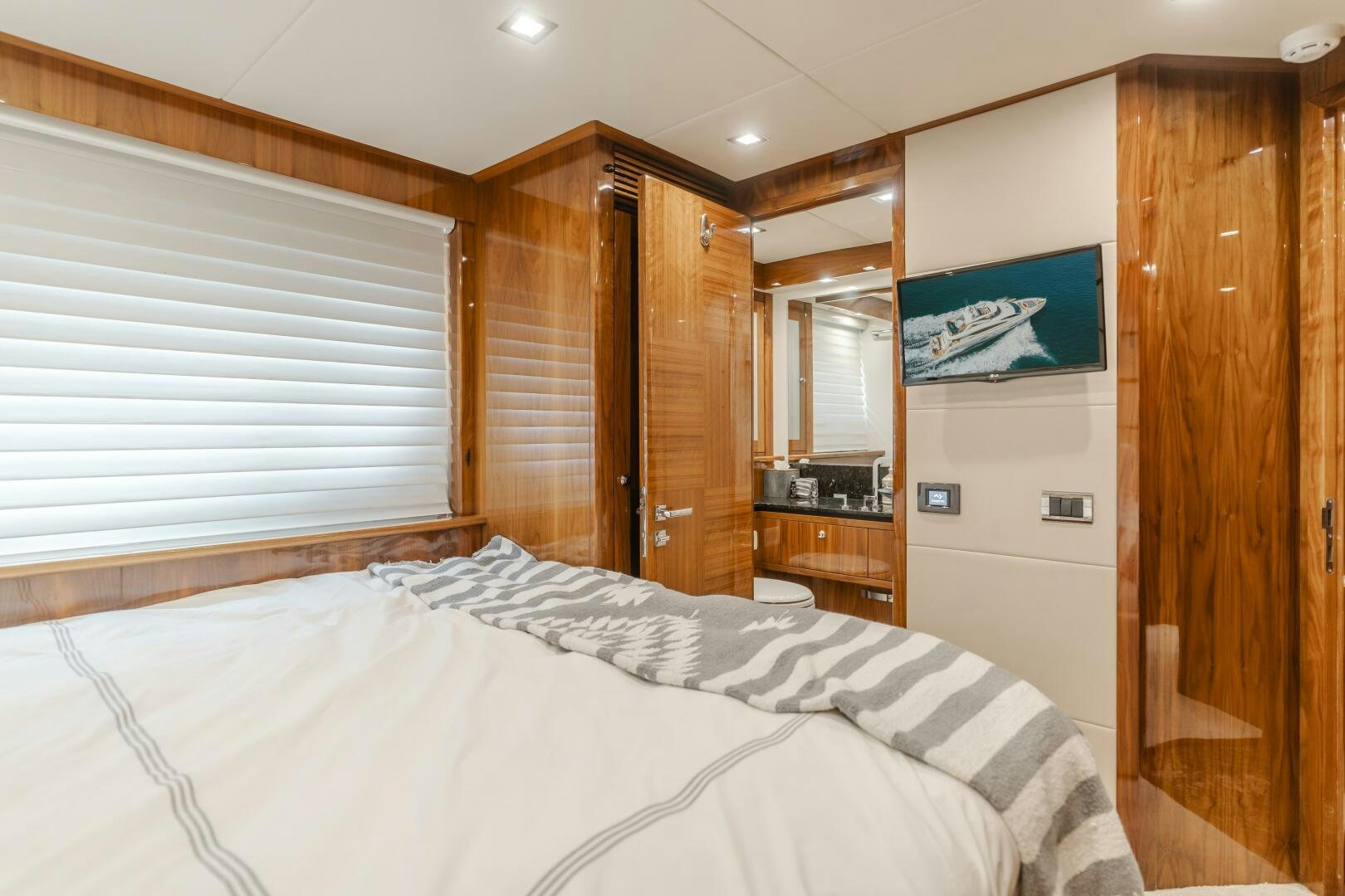 a bedroom with a bed and a television aboard INDECENT PROPOSAL IV Yacht for Sale
