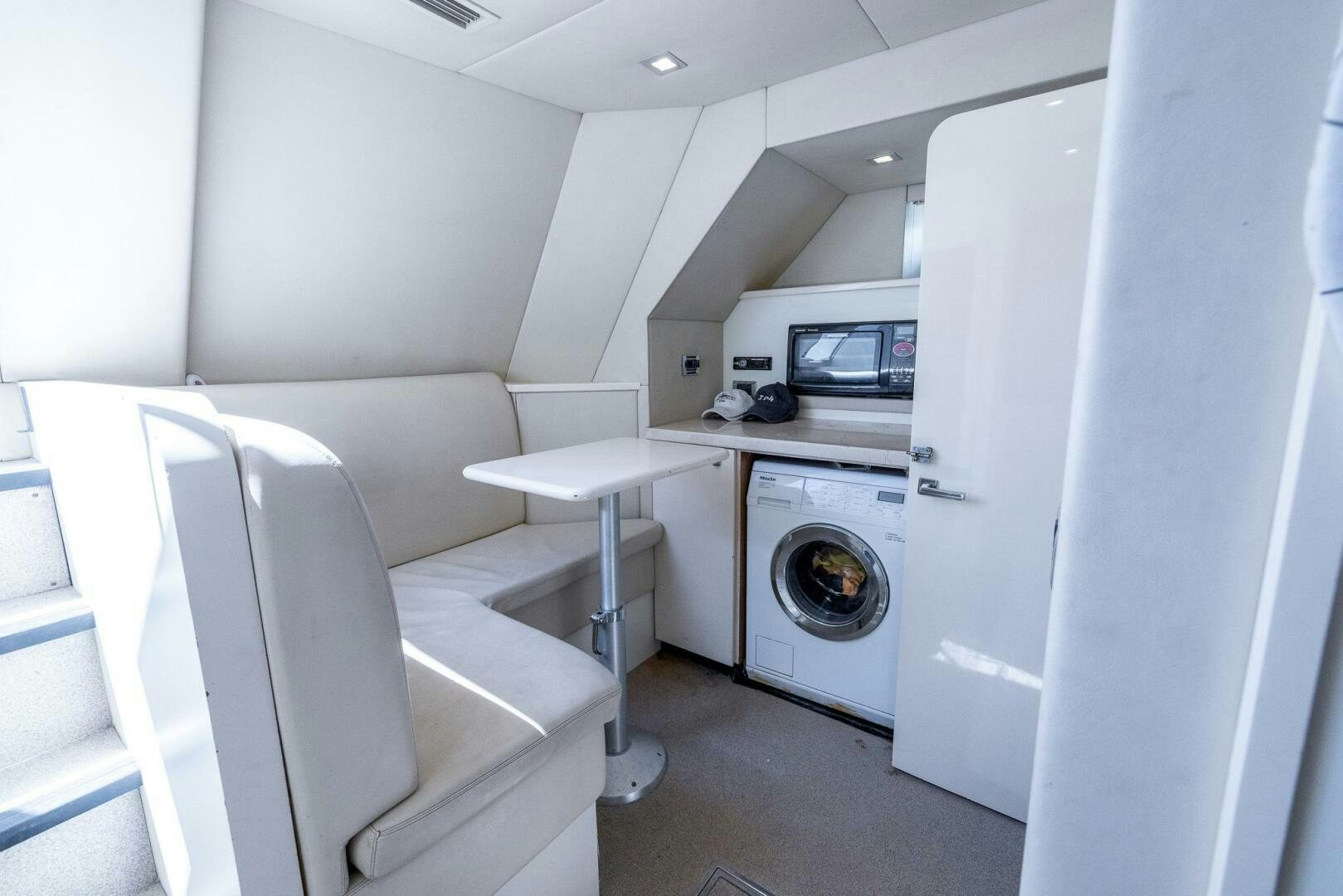 a room with a washing machine and a microwave aboard INDECENT PROPOSAL IV Yacht for Sale